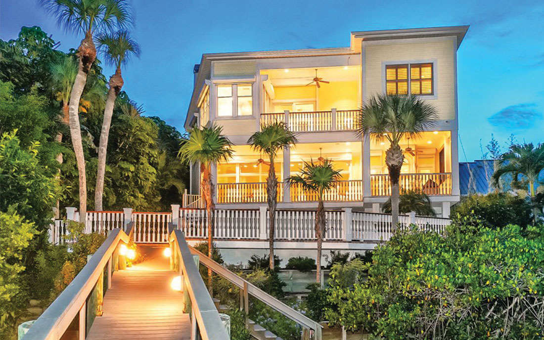 View of lighted home at night from boat dock