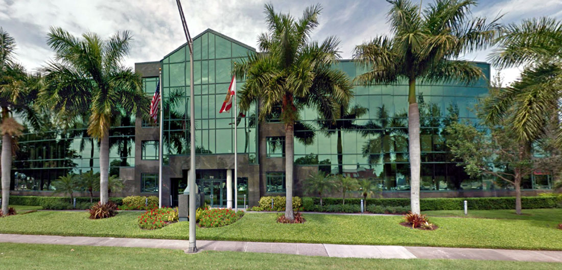 Exterior of 1250 Medical Plaza building with green glass and many palm trees