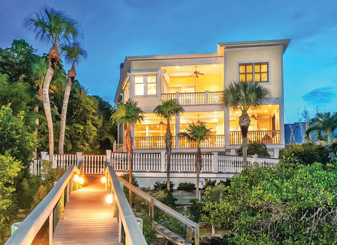 View of luxury home at night from its private boat dock
