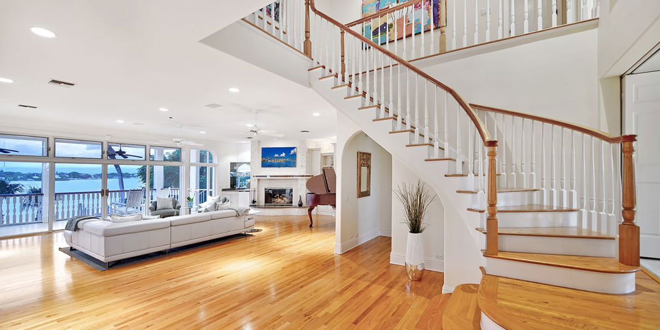 Surving stiarway in modern Florida home with hardwood floors and ocean view