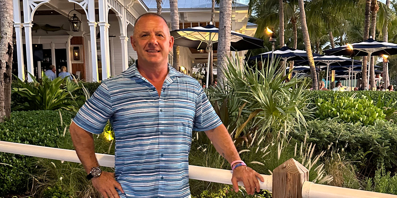 Chris Deveso standing in front of tropical landscaping 