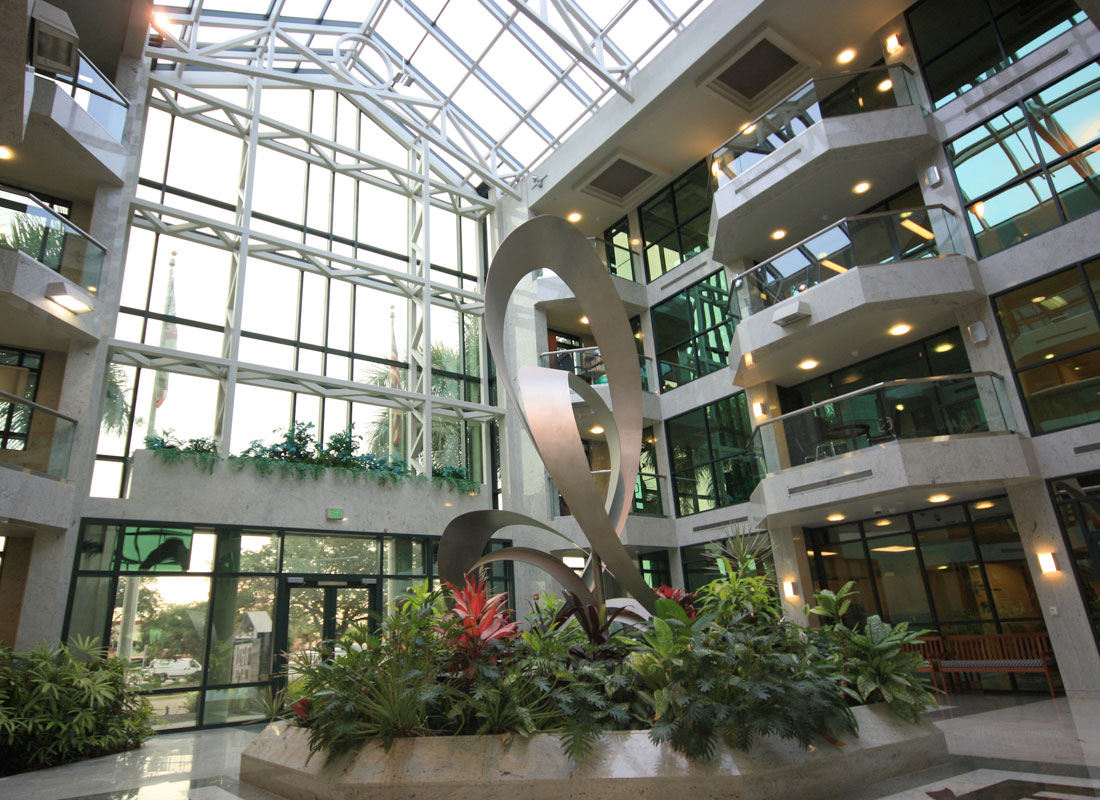 Two-story metal sculpture in building atrium with three-story high glass windows