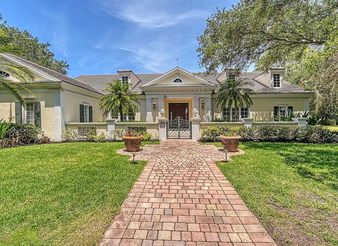 Home-Hillview-Living-Room Front of traditional Spanish style home with long red brick path to the front door.